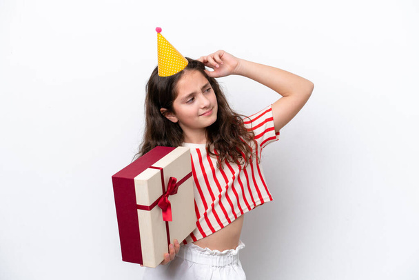 girl in birthday hat holding gift box on white background  - Фото, изображение