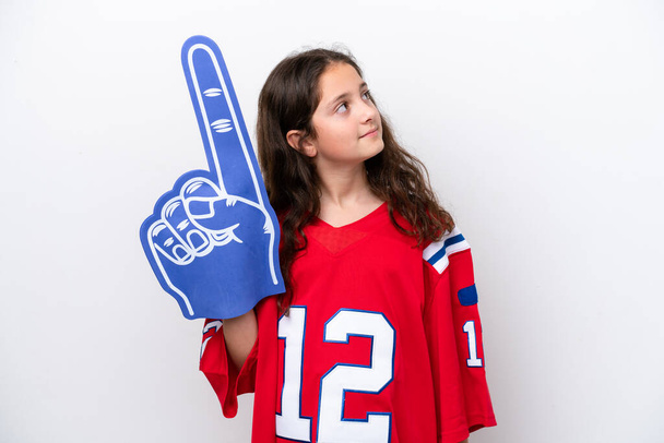 Little sports fan girl isolated on white background looking up while smiling - Photo, Image