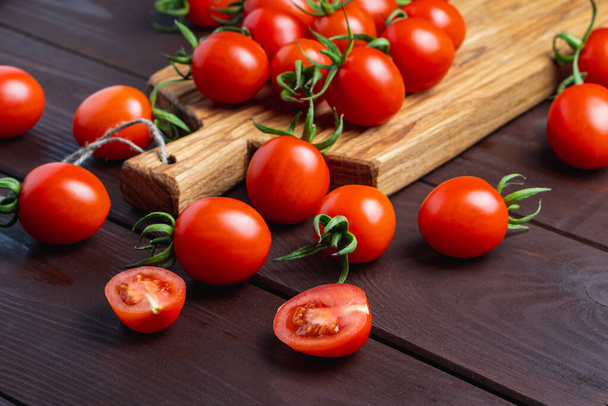 Punainen tomaatti lasi kulhoon leikkuulauta puinen pöytä. Orgaanista terveellistä ruokaa. Ruoanlaitto ainesosia. Pomodoro pöydällä - Valokuva, kuva