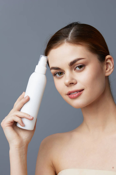 woman skin care lotion with bare shoulders isolated background - Фото, зображення