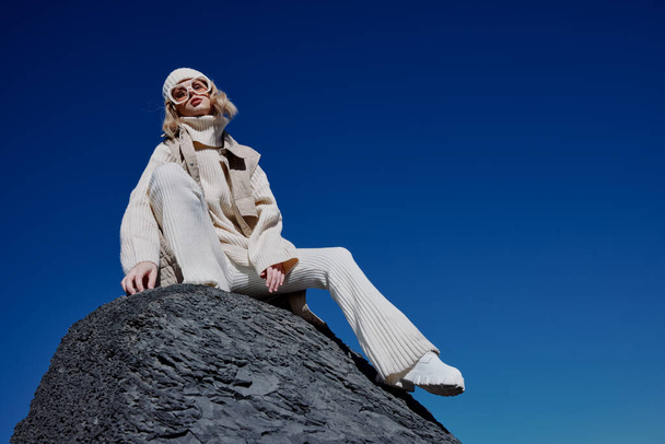woman in autumn clothes stands on a rock landscape blue sky lifestyle - Photo, Image
