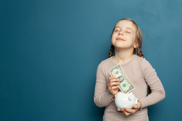 Opgewonden kind meisje dromen en houden spaarvarken bank - Foto, afbeelding