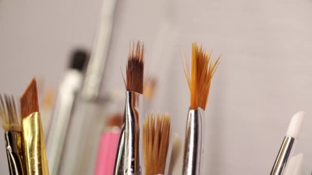 Kosmetik-Make-up-Pinsel zum Auftragen von Kosmetika auf das Gesicht werden im Makro auf weißem Hintergrund gefilmt - Filmmaterial, Video