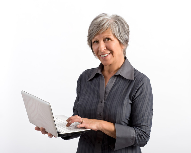 Uśmiechający się nowoczesne dorosła kobieta korzysta z laptopa - Zdjęcie, obraz