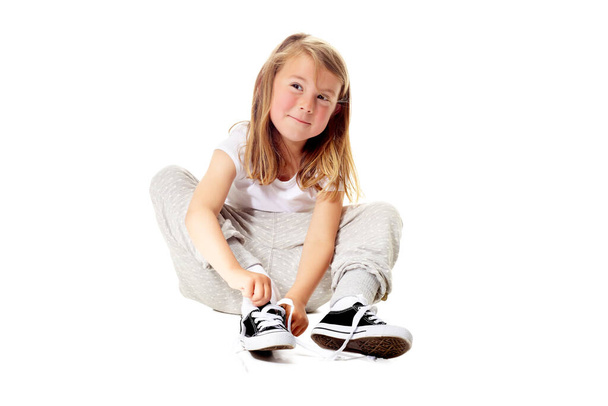 Did you know I can tie my own shoelaces. Shot of a cute little girl isolated on white. - Zdjęcie, obraz