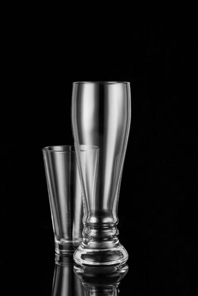 Two empty glass beer glasses on a black background. Object shooting. - Фото, зображення