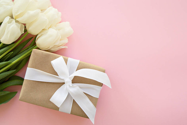 白いチューリップの花とピンクの背景の贈り物テキストのための場所。郵便はがきだ。休日だ。女性の日。バレンタインデー。母の日 - 写真・画像