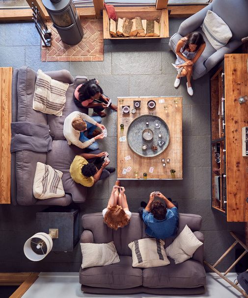 Overhead Shot Of Multi-Cultural Group Of Friends At Home Playing Cards And Drinking Beer And Wine - 写真・画像