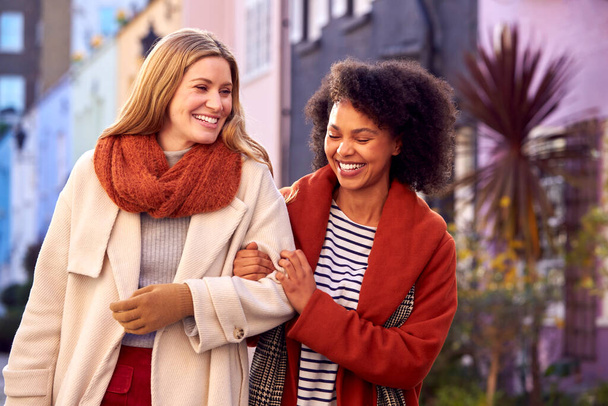 Жінка зустрічається жінка друг ходить по житловій міській вулиці восени або взимку
 - Фото, зображення