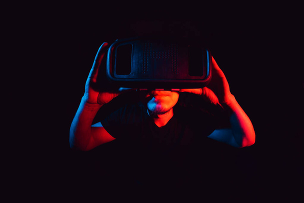 Hombre joven con auriculares de realidad virtual VR. educación en línea, estudio de concepto - Foto, imagen