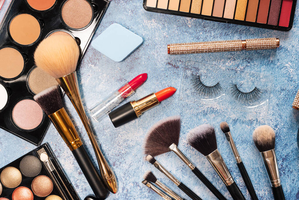 set of decorative cosmetics, makeup brushes on a blue background. the view from the top - Foto, Imagem