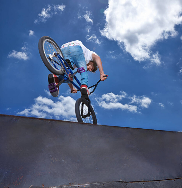 Practicing for the x games. Rearview shot of a teenage boy riding a BMX at a skatepark. - Photo, Image