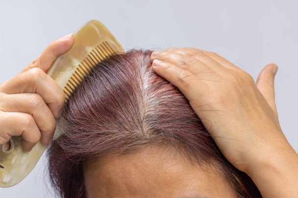 Keski-ikäinen aasialainen nainen huolta harmaita hiuksia vaihdevuodet. - Valokuva, kuva