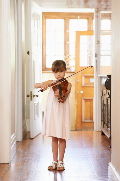 Uczę się gry na skrzypcach. Ujęcie młodej dziewczyny grającej na skrzypcach. - Zdjęcie, obraz