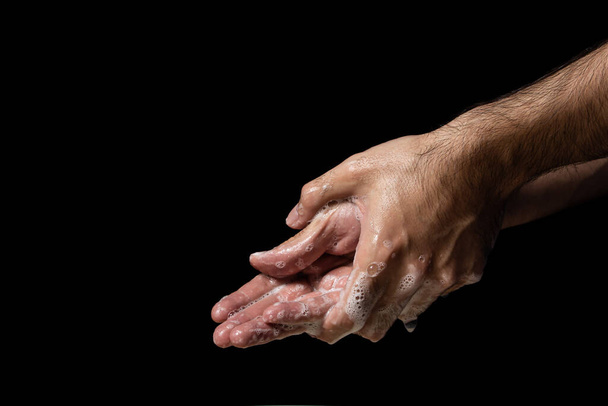 Händewaschen mit Seife auf schwarzem Hintergrund. Körperpflege und Gesundheitsfürsorge. - Foto, Bild