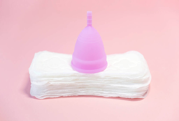 Menstrual cycle. Alternative means of hygiene and protection in critical days for women.Tampons or silicone menstrual cup on  pink background. Concept: reuse, eco, safety. Selective focus. Copy space. - Foto, Bild