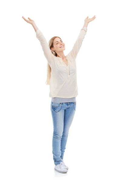 Somedays its just great to be alive. Full length studio shot of a young woman with her eyes closed raising her arms over her head isolated on white. - Photo, image