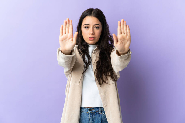 Mladý kavkazský žena izolovaný na fialové pozadí dělat stop gesto a zklamaný - Fotografie, Obrázek