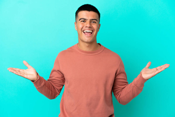 Young handsome man over isolated blue background with shocked facial expression - Foto, immagini
