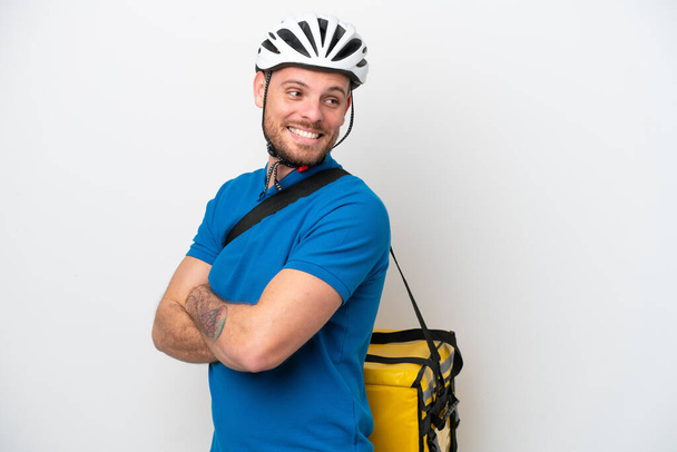Young brazilian man with thermal backpack isolated on white background with arms crossed and happy - Φωτογραφία, εικόνα
