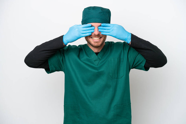 Cerrah Brezilyalı yeşil üniformalı adam, beyaz arka planda tek başına, gözleri elleriyle kapatıyor. - Fotoğraf, Görsel