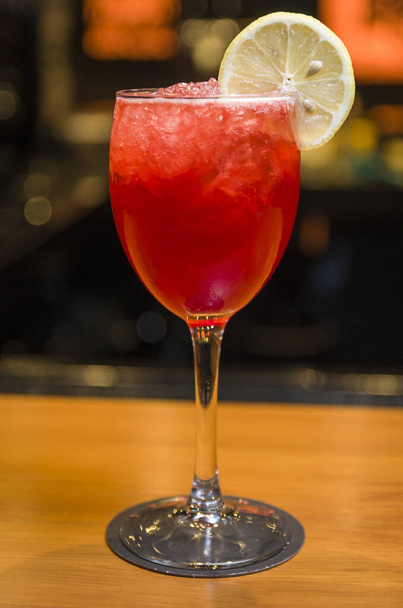 Close-up of delicious drink in glass of red berries, lemon and gin. - Foto, immagini