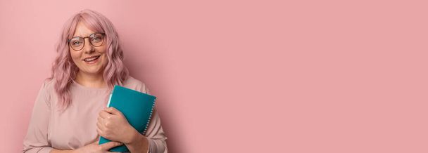 Усміхнена щаслива студентка в окулярах тримає книги ізольовані на рожевому кольорі портрет студії з вільним простором копіювання, банер
 - Фото, зображення