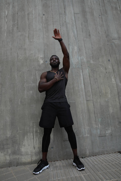 Full-length photo of Black young man doing hard workout outdoors. Vertical. - Фото, изображение