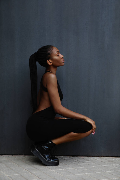 Gorgeous woman with black braided hair posing on dark background. Vertical. - Valokuva, kuva