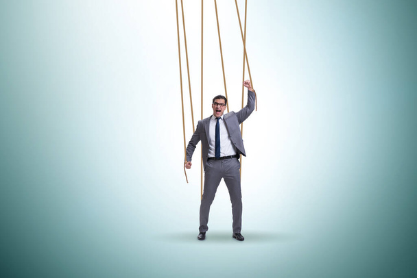 Hombre de negocios títere siendo manipulado por cuerdas - Foto, Imagen