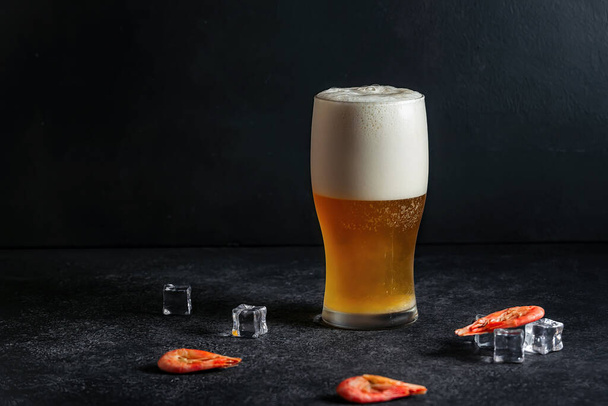 alcoholic drink beer on a dark background and shrimp - Foto, Bild