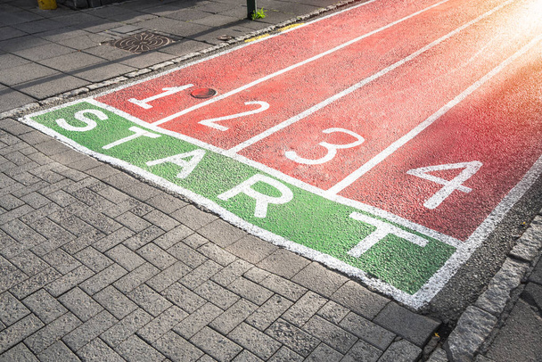 Pistas para correr pintadas en la superficie de una calle empedrada peatonal. Nuevo concepto de inicio. - Foto, imagen