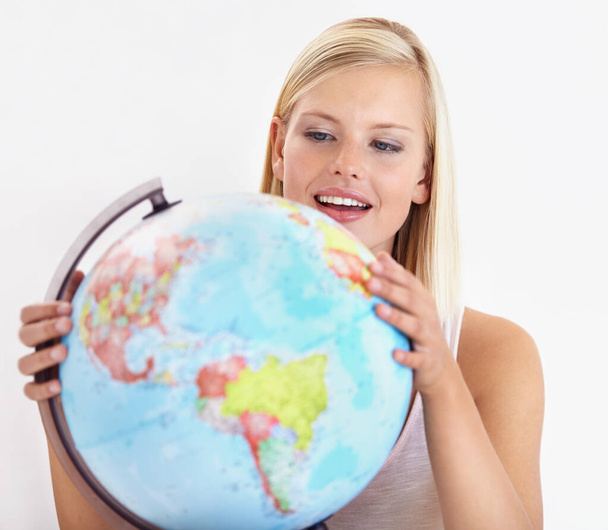 Ah, heres a place I havent explored yet. A pretty young woman looking at a globe of the earth. - Foto, afbeelding