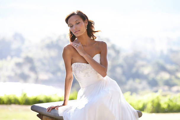 Elegance and grace personified. Gorgeous young bride outdoors in her wedding dress. - Photo, Image