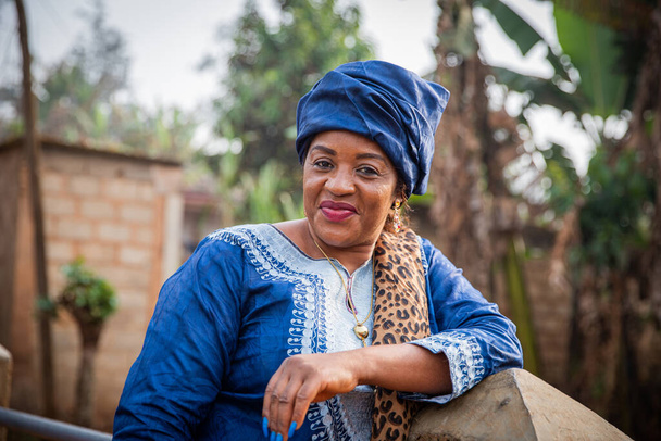 Portret atrakcyjnej i uśmiechniętej 50-letniej Afrykanki ubranej w tradycyjną afrykańską sukienkę - Zdjęcie, obraz