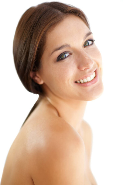 Haar glimlach brengt een schittering in haar ogen. Portret van een mooie jonge brunette op een witte achtergrond. - Foto, afbeelding