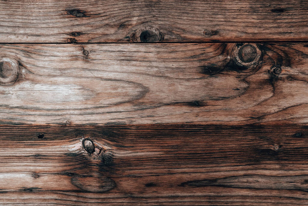 Деревянный текстурный фон, выветренная коричневая доска из сарая. Тёмная поверхность фона из дерева со старым природным узором - Фото, изображение