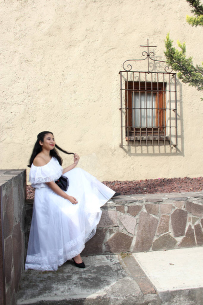 Junge Frau aus Veracruz Teenager trägt ein weißes mexikanisches Regionalkleid sehr glücklich und stolz auf ihre Tradition oder Kultur in den kolonialen Straßen von Mexiko - Foto, Bild
