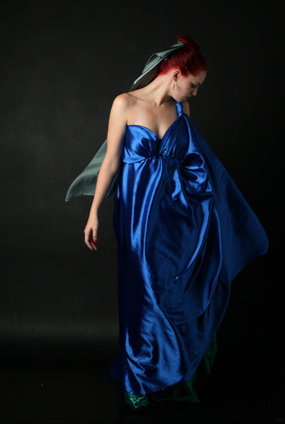 Ολόσωμο πορτρέτο όμορφου γυναικείου μοντέλου που φοράει φόρεμα Ελληνίδας θεάς toga, ποζάρει με κομψές χειρονομιακές κινήσεις σε φόντο στούντιο. - Φωτογραφία, εικόνα