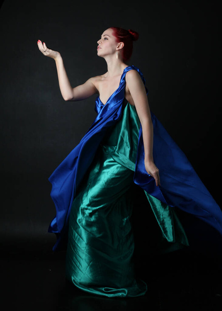  Full length portrait of pretty female model wearing  grecian goddess  toga gown, posing with elegant gestural movements on a studio background. - 写真・画像