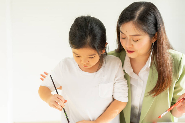 Tatlı küçük çocuklar resim yapmayı, öğretmenleriyle birlikte fotokopi odası olan eğitim sınıfında öğrenmeyi planlıyorlar. Asyalı güzel çocuklar mutlu ve eğlenceli boyama eğitimi küçük okullarda - Fotoğraf, Görsel