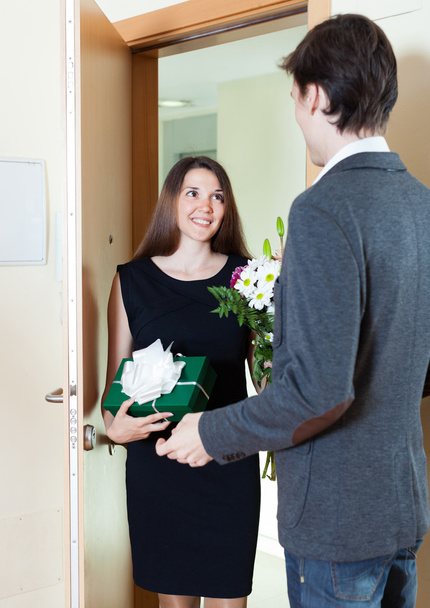 Man receives a gift from a woman and flowers - Φωτογραφία, εικόνα