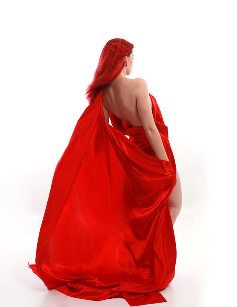 Plně dlouhý portrét rudovlasé ženy v krásném sexy hedvábném kostýmu, stojící póza s kreativními gesty paže, izolované na bílém pozadí studia. - Fotografie, Obrázek