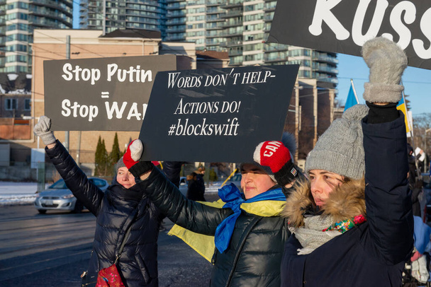 Toronto, ON, Kanada 25 lutego 2022: Protestujący z chorągwiami i flagami ukraińskimi w pobliżu ukraińskiego konsulatu podczas demonstracji przeciwko wojnie rosyjskich agresorów na Ukrainie. - Zdjęcie, obraz