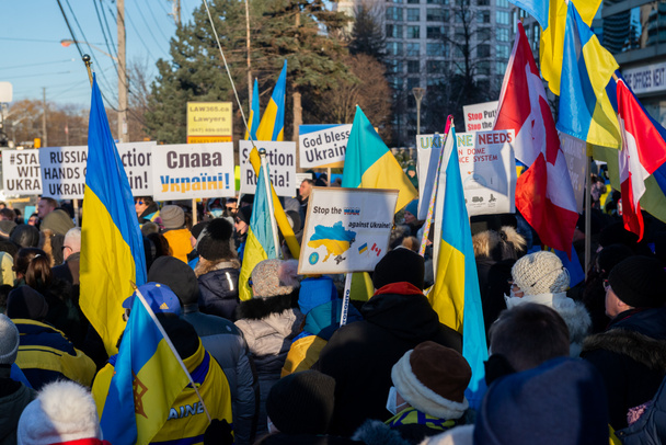 Toronto, ON, Canadá 25 de fevereiro de 2022: Protestantes com bandeiras e bandeiras ucranianas perto do Consulado Ucraniano durante a manifestação contra a guerra dos agressores russos na Ucrânia. - Foto, Imagem