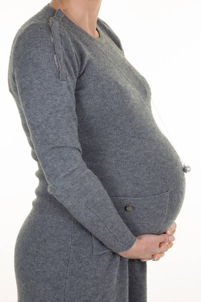 pregnant belly profile view of woman in fashion dress hands on tummy - Фото, зображення