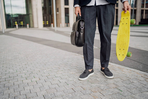 A banker in a business suit. The manager is riding a skateboard in a hurry to a meeting. A male economist rides a board to work with a briefcase. - Photo, Image