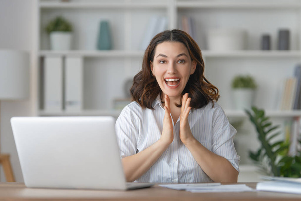 Happy casual beautiful woman working on a laptop in the office. - 写真・画像