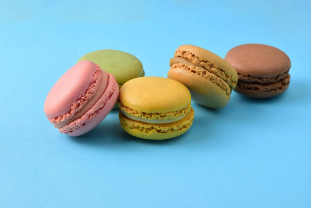 Colored macarons, isolated on blue background, typical french sweet. - Photo, Image