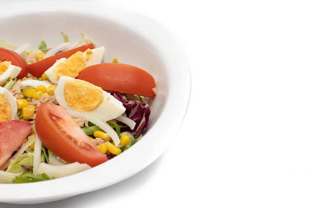 Ανάμεικτη σαλάτα σε λευκό μπολ. Υλικά μαρούλι, καλαμπόκι, κρεμμύδι, τόνος, ντομάτες, αυγά, ελαιόλαδο, κόκκινο λάχανο. Μεσογειακή έννοια τροφίμων. - Φωτογραφία, εικόνα